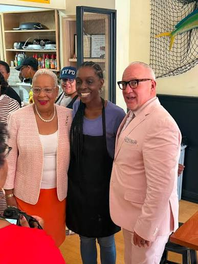 Aunt Hocker smiling with guests inside her North 3rd Street kitchen