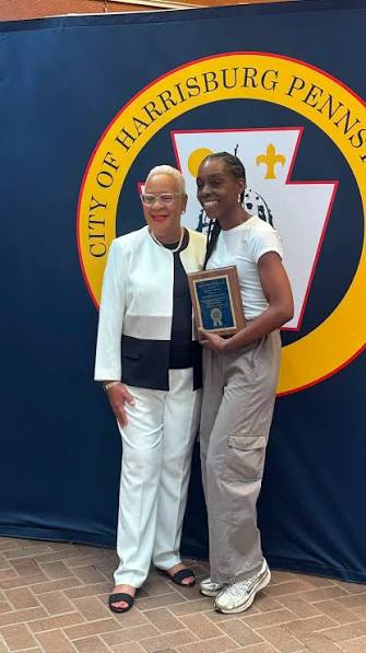 Aunt Hocker receiving a City of Harrisburg award in front of the city seal